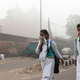 Kids in Delhi cover their faces as they walk to school amid heavy smog